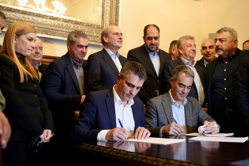 Der griechische Minister für Infrastruktur und Verkehr, Christos Dimas (links), unterzeichnet das Protokoll zur Einleitung der Konzessionsphase für den Abschnitt Chania–Hersonissos der Nordstraßenachse Kretas (BOAK) zusammen mit Manos Moustakas, Vizepräsident des Konzessionsunternehmens DIKTAION S.A. und Generaldirektor für Geschäftsentwicklung bei der GEK TERNA Group.